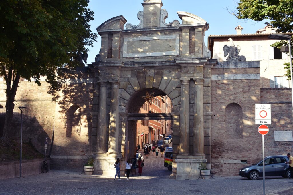 A large brick entrance gate through which people pass.