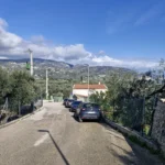 A roadway with several cars parked on it