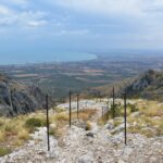 metal stakes and ropes driven into the rock mark the route. In the distance you can see greenery and the sea