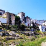 White geometric houses stand on a hill