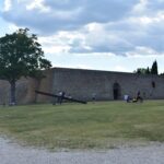 In some places, yellowed grass grows against the walls of the stone fortress.